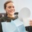 Smiling woman in dental chair looking in mirror, showcasing dental implants, representing Newnan dental care and implant dentistry for a smile makeover.